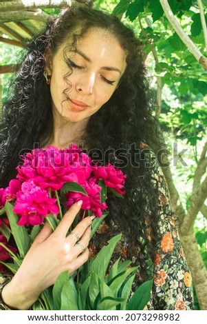 woman holding a bouquet of pink peonies