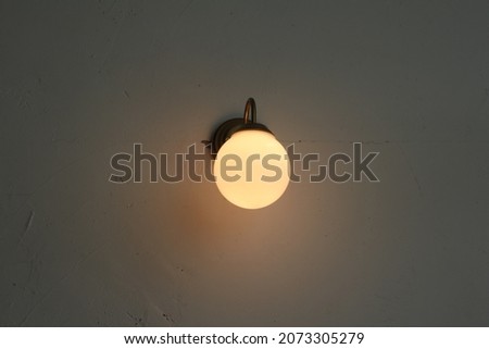 Vintage light bulb on the wall in low light room