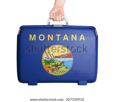 Used plastic suitcase with stains and scratches, printed with flag, Montana