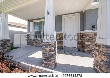 Facade of a house with column posts on the porch with stone veneer siding Royalty-Free Stock Photo #2073315278