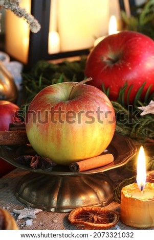 Traditional Christmas decoration with apples, cinnamon sticks and candles. 