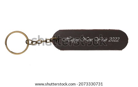 Leather keychain with Happy new yaer 2022 word isolated on white background. Brown Color , Happy new year label accessory chain with key 