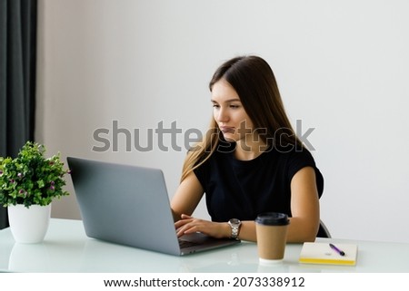 Portrait of a young business woman using laptop at office