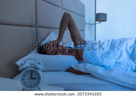 Woman with insomnia lying in bed with open eyes. Girl in bed suffering insomnia and sleep disorder thinking about her problem at night. Woman in bed late night trying to sleep suffering insomnia Royalty-Free Stock Photo #2073341603