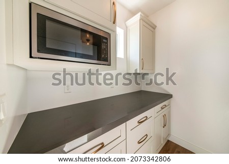 White kitchen interior with alcove sleek dark gray kitchen countertop Royalty-Free Stock Photo #2073342806