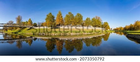 A picture of the Ostravice river and the foliage, in Ostrava, in the fall.
