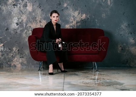 a beautiful woman is sitting on the sofa with a brush