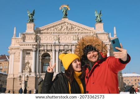 couple tourists taking selfie in front of opera building of lviv city ukraine