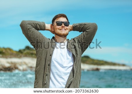 young man in sunglasses with beard portrait at seaside. summer vacation