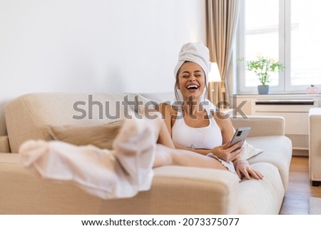 Moisturizing foot mask, for dry heels of the feet. Woman wearing disposable moisturizing socks for the legs. After a shower, a girl wrapped in a towel uses moisturizing foot mask. Cosmetic trends 