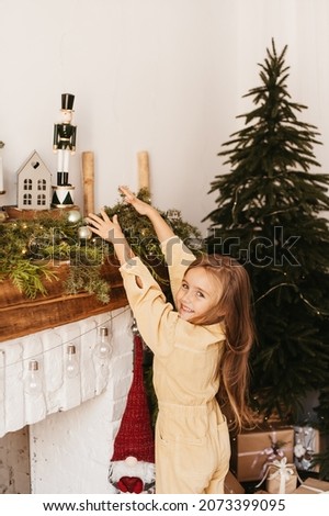 adorable girl tries to reach the toy on christmas background