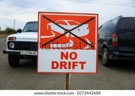 no drift sign with car in street
