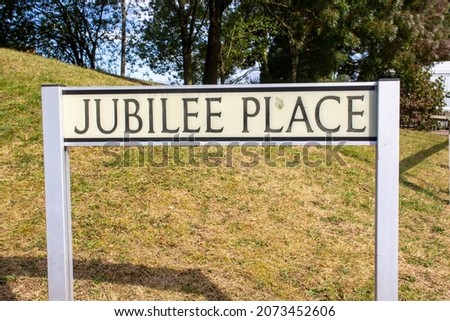Jubilee Place street name sign on two posts with a grass bank in the background