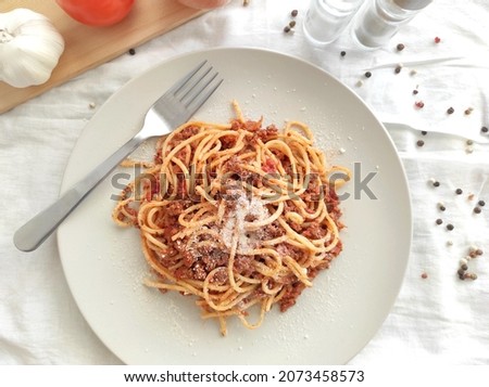 Spaghetti Bolognese with minced beef, onion, chopped tomato, garlic, olive oil, stock cube, tomato puree and Italian herb. Traditional Italian food on a plate.