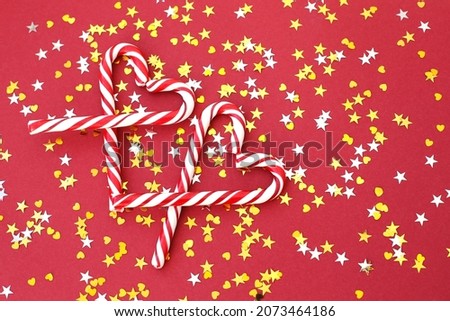 Delicious, whole Christmas candy canes on a bright, full-screen background.