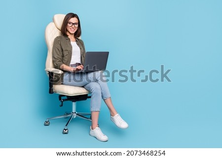 Full body photo of ceo lady sit chair use device texting typing message wear khaki denim outfit isolated over blue color background Royalty-Free Stock Photo #2073468254