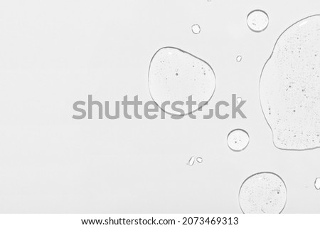 Cosmetic product clear drops and space for design on white Royalty-Free Stock Photo #2073469313