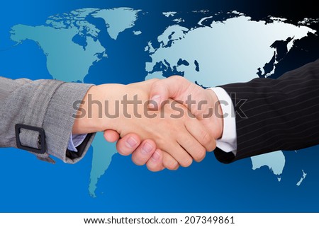 Cropped image of businessmen shaking hands against world map.