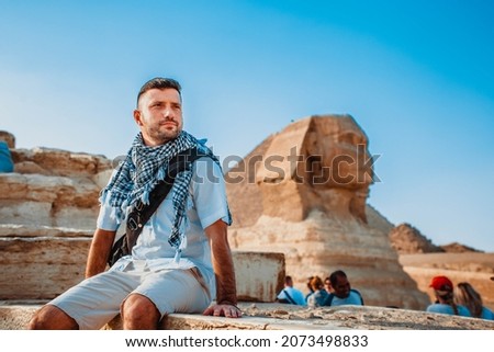 A young man of tourists takes pictures in front of the pyramids and the Sphinx of Giza in Cairo, the capital of Egypt.