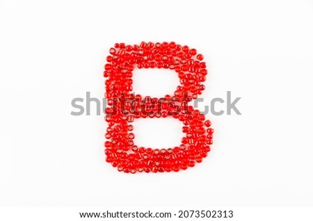 Alphabet of red beads on white background B
