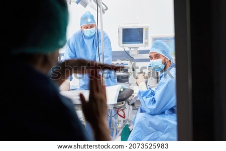 Female doctor gives time-out hand signals to medical team in the intensive care unit for overtime and break Royalty-Free Stock Photo #2073525983