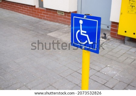 A close up of a Blue sign showing a parking spot for disabled people