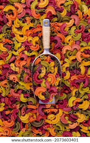Multicolored dry pasta in a metal scoop. Background. Texture. design concept. Copy space.