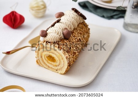 Buche de Noel. Traditional Christmas dessert, Christmas yule log cake with vanilla cream. Christmas tree branches. Royalty-Free Stock Photo #2073605024