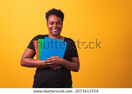 Mature student woman smiling looking at camera with space for text on yellow background. Mature black student woman
