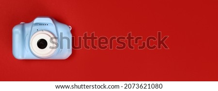 plastic toy camera for children on a red background, horizontal banner. Copy space for text