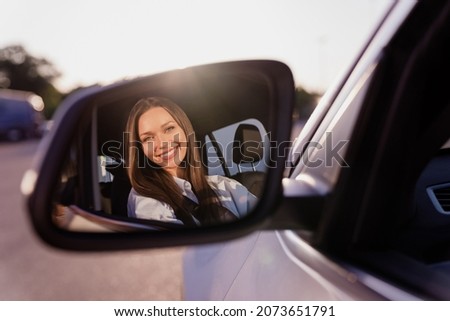 Photo of sweet cute young lady dressed white shirt smiling looking back mirror driving automobile outdoors urban route Royalty-Free Stock Photo #2073651791