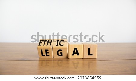 Ethical or legal symbol. Turned wooden cubes and changed the word 'legal' to 'ethical' on a beautiful wooden table, white background. Business and ethical or legal concept. Copy space.