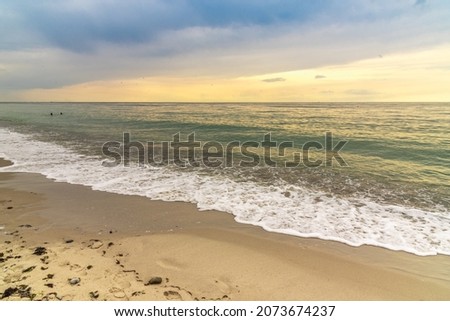 Sandy seashore. The tide is out. Waves are breaking on a sandy beach. Along the seashore. Evening is falling over the pond. Seascape at sunset. Vacation on the Baltic Sea coast.