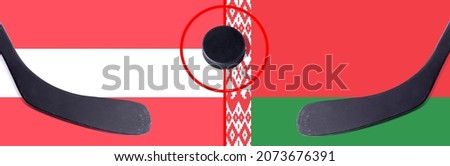 Top view hockey puck with Austria vs. Belarus command with the sticks on the flag. Concept hockey competitions