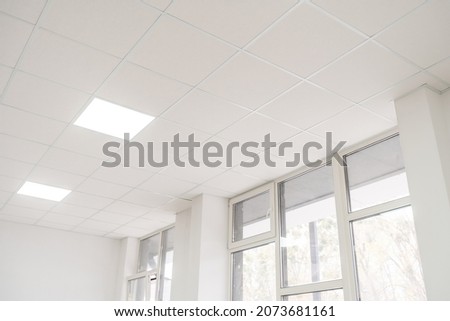 Acoustic ceiling with lighting and light channel window, Acoustic ceiling board texture Sound-proof material, Sound absorber, industry construction concept background black and white tone Royalty-Free Stock Photo #2073681161