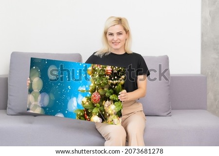 woman holding a photo canvas with a picture of christmas