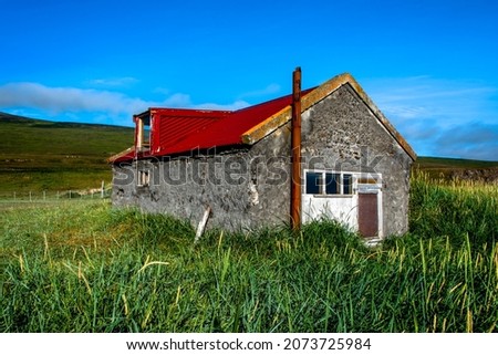 old fisherman's house with red tin roof in the Hunafiordur fjord in Northern Iceland
