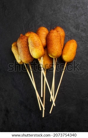 Corn dog cooked with sausage and wheat dough with the addition of corn flour,black background top view Royalty-Free Stock Photo #2073754340