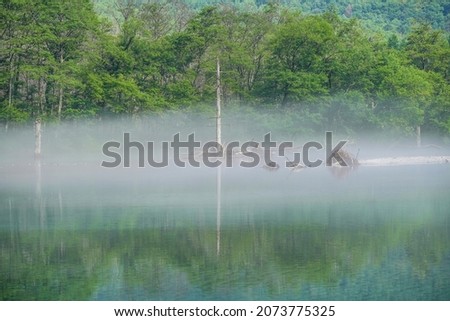 Fantastic scenery of Taishoike Pond surrounded by the morning mist at Kamikochi, Nagano pref.