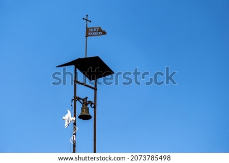 An old and small bell-cote with a background of blue sky  Royalty-Free Stock Photo #2073785498