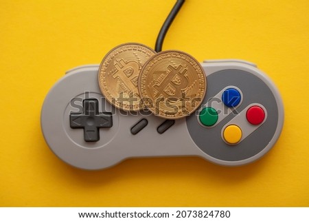 Crypto gaming concept. Video game controller with a bitcoin cryptocurrency coin Royalty-Free Stock Photo #2073824780