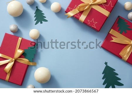 Light blue background with christmas ornament , pine tree twinkle pearl and red gift box with yelllow ribbon , blank space for merry christmas holiday advertising 