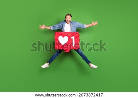 Full length body size photo of overjoyed guy jumping high with social media feedback sign isolated bright green color background