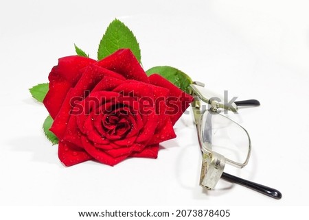 Fresh red rose and eye glasses isolated on white background.