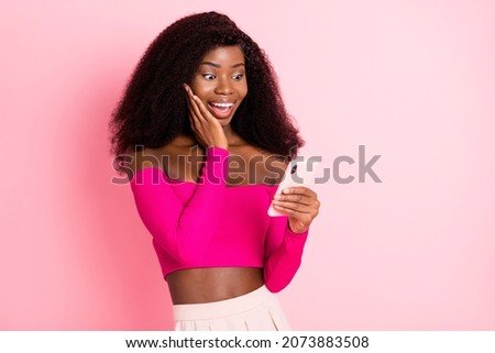 Photo of excited crazy lady hold phone palm cheek wear top unclothed shoulders isolated pink color background