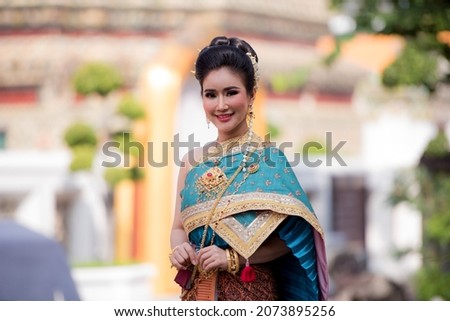 Beautiful Thai girl in traditional dress costume in Thailand temple show Jasmine garland with smiling