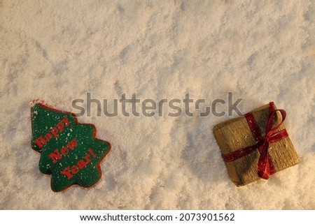 beautiful green Christmas tree and a gift lies on the white snow