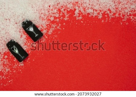  Christmas nail picture . Christmas flat lay with copy space on red bachground with snow. wineglass with champagne on black background  . beauty salon concept .