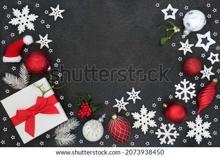 Christmas  giving concept with gift box, bauble tree decorations, stars, snow covered fir, mistletoe, holly on grey grunge. Creative abstract background   layout for the holiday season. Flat lay.