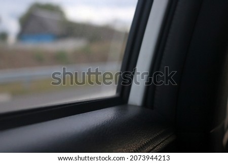 Picture of the corner of the car window in the photo with slightly dark lighting